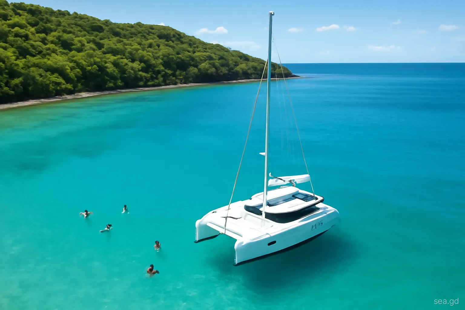 Wide aerial view of a white sailing catamaran anchored in a turquoise bay on Grenada's green west coast, swimmers in the water, bright late-morning sun